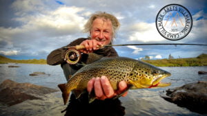 Bilde av Bengt-Are Barstad som vant prisen Årets Villmarking 2023. Han har en fiskestang og en fisk i hendene.